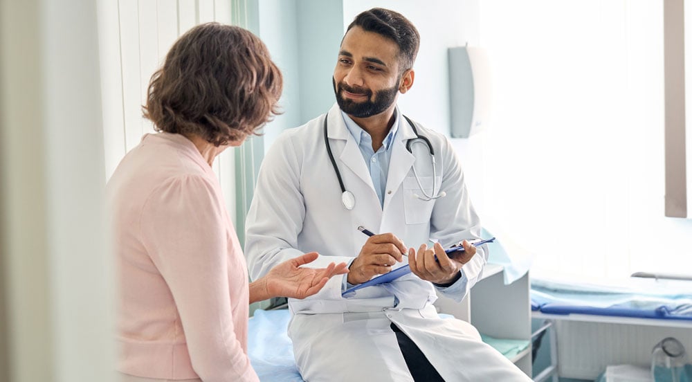 Médico conversando com uma paciente que utiliza o benefício de desconto em saúde da Sem Parar Empresas 