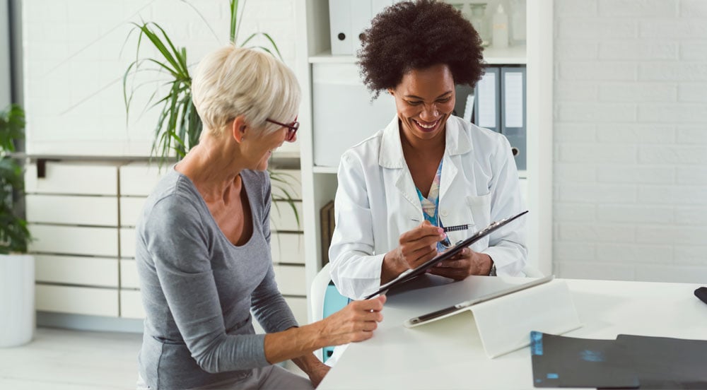 Médica atendendo a uma paciente que pode utilizar o auxílio saúde fornecido por sua empresa