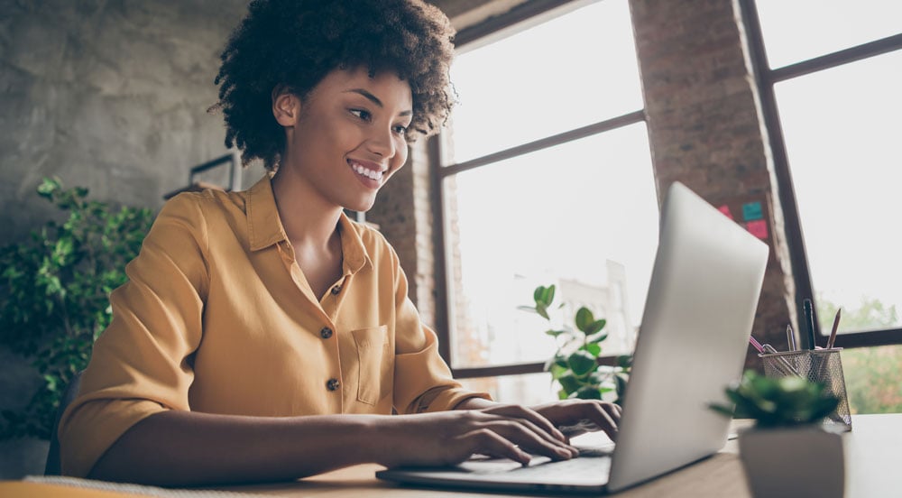 Mulher em frente ao computador fazendo a gestão do Vale-Transporte Sem Parar Empresas