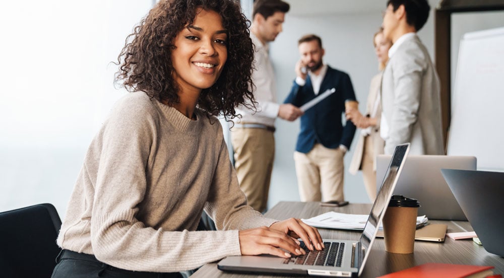 Mulher mexendo em notebook no escritório para centralizar as tarefas de gestão de RH com a Sem Parar Empresas