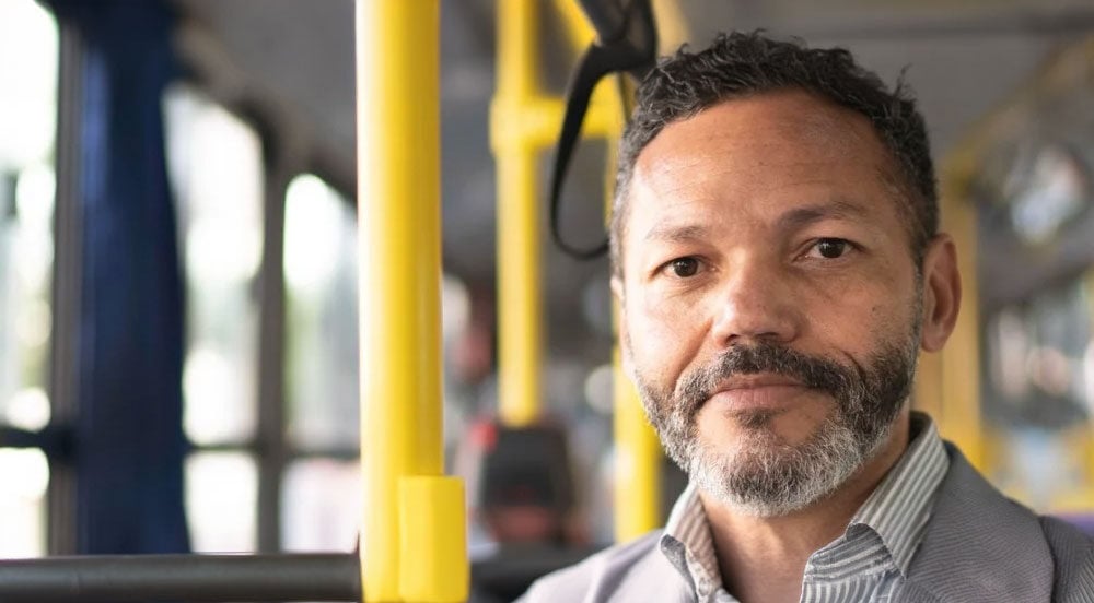 Homem indo para o trabalho em ônibus, pois seu empregador fez a solicitação de vale-transporte com a Sem Parar Empresas